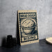 A sign with the text "BREAD DOUGH RISING" and an illustration of a bowl of dough, placed on a countertop next to some black containers.