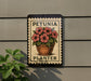 A sign with a potted plant and the text "PETUNIA PLANTER" is displayed on a wall, with a plant visible to the left.