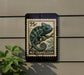 A 25c postage stamp featuring a chameleon is displayed on a wall, with a plant visible to the left.
