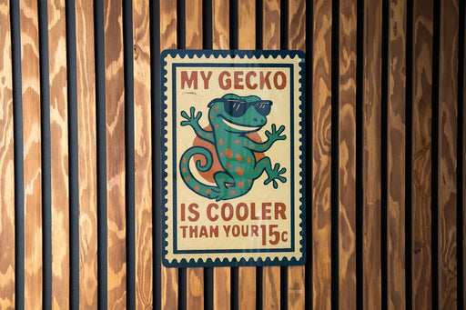 A vintage-style metal sign with a gecko wearing sunglasses and the text "MY GECKO IS COOLER THAN YOUR 15¢" is displayed on a wooden wall.