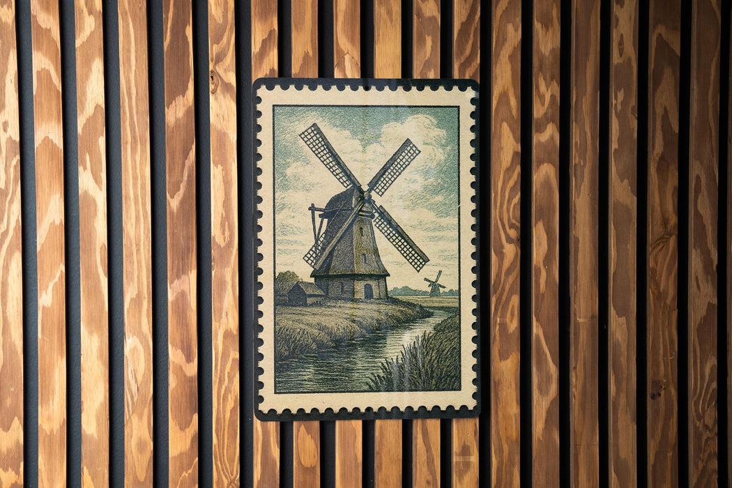A framed illustration of a windmill is displayed on a wooden wall.