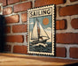 A vintage-style metal sign with a sailboat illustration is mounted on a brick wall.