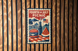A vintage-style poster for the 4th of July picnic, featuring a hamburger, watermelon, and an American flag, is displayed on a wooden wall.