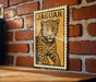 A framed image of a jaguar is displayed on a brick wall.