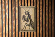 a wooden wall with a framed illustration of a praying mantis.