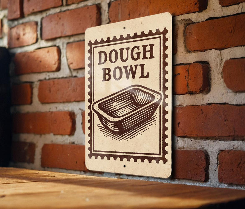 A sign with the text "DOUGH BOWL" is displayed on a brick wall, with a wooden table below it.