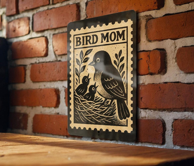 A black and white illustration of a bird, likely a mother bird, with her two young birds in a nest, is displayed on a brick wall.