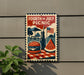 A sign that reads "Fourth of July Picnic" with an illustration of a hamburger, watermelon, and a picnic table.