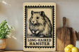 A wooden shelf displaying a framed image of a long-haired hamster, a potted plant, a wooden cutting board, and some lemons.
