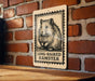 A wooden table with a wooden border, and a sign featuring a hamster illustration on it.