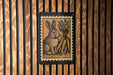 A wooden wall with a framed image of a rabbit and carrots, which appears to be a decorative piece.