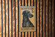 A metal sign featuring a close-up of a Scottish 5c postage stamp with a depiction of a greyhound dog.