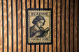 A vintage-style reading sign is displayed on a wooden wall, featuring an illustration of a woman reading a book.