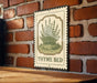 A metal sign with a vintage design hangs on a brick wall, featuring a depiction of a thyme plant and the text "THYME BED".