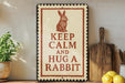 A sign with the text "KEEP CALM AND HUG A RABBIT" is displayed on a shelf, accompanied by a wooden cutting board and a potted plant.
