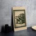 a wooden sign with a turtle illustration on it, placed on a table next to some black camera lenses.