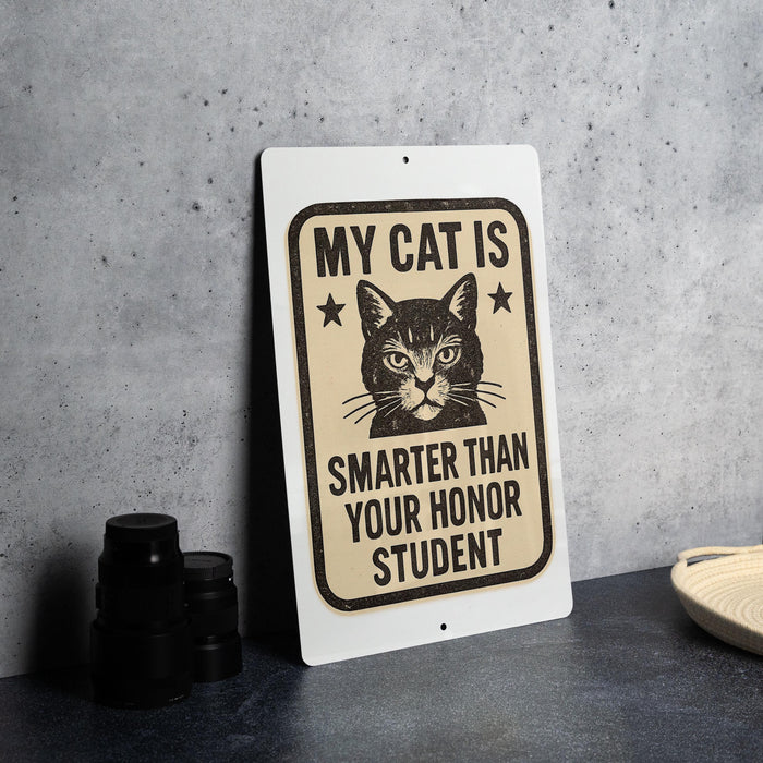 A sign with a cat and the text "MY CAT IS SMARTER THAN YOUR Honor STUDENT" is displayed on a table.