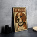 A metal sign featuring a beagle dog with the name "Beaglier" written on it, placed on a table next to some black camera lenses.