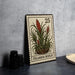 A metal stamp featuring a plant illustration, placed on a table next to some black camera lenses.