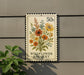A postage stamp-like sign with a floral design and the text "Wildflower Bouquet" is mounted on a wall.