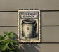 a sign for a "Stoneware Crock" with a black and white illustration of a crock on a wall.