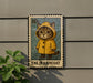 A postage stamp featuring a cat wearing a yellow raincoat, with the text "CAT IN RAINCOAT" printed on it.