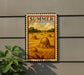 A framed illustration of a field with hay bales, depicting a rural scene with a cloudy sky in the background.