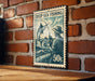 A vintage-style postage stamp featuring a man fishing, mounted on a brick wall.