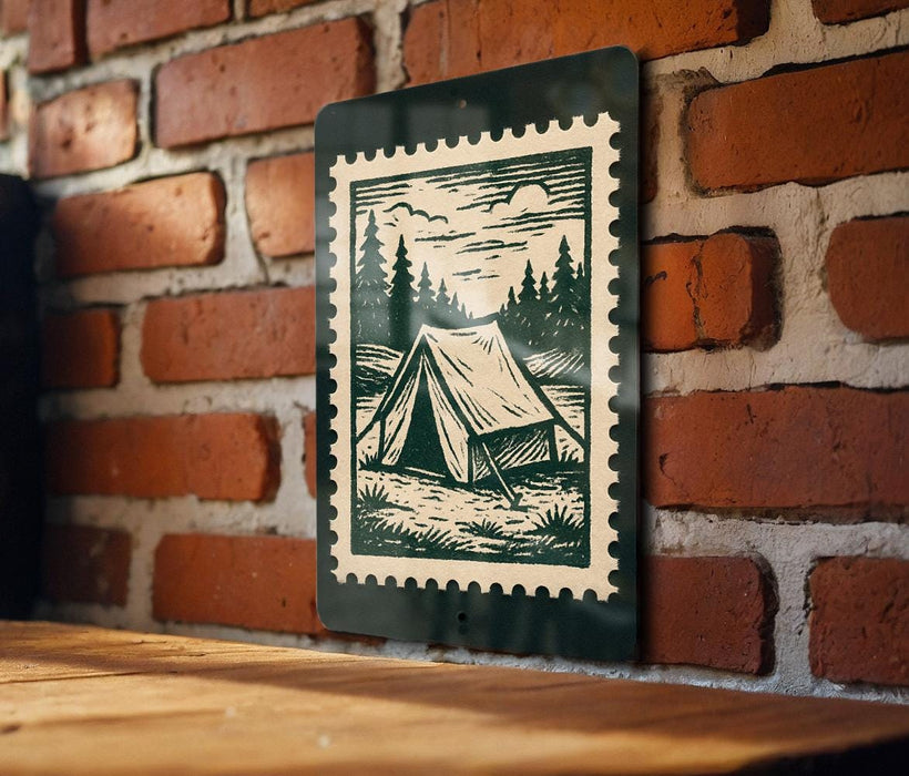 A green and white stamp-like sign is mounted on a brick wall, depicting a tent in a wooded area.