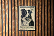 A metal stamp featuring a black and white illustration of a Welsh sheepdog.
