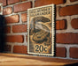 A 20c postage stamp featuring a salamander is displayed on a brick wall.