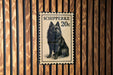 A black and white postage stamp featuring a dog, with the text "SCHIPPERKE 20c" printed on it.