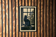 A black cat sitting on a windowsill, looking out of a window, is depicted in the image.