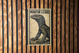 A poster of a monitor lizard is displayed on a wooden wall.