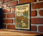 A vintage-style metal sign with a floral design is mounted on a brick wall, depicting a meadow with wildflowers.