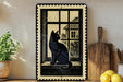 A framed illustration of a black cat sitting on a windowsill, looking out of a window, is displayed on a shelf next to a wooden cutting board and some lemons.