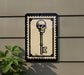 a key with a skull on it, mounted on a wall.