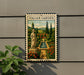 a vintage-style metal sign with a painting of a garden and a statue, mounted on a wall.