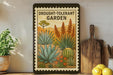 a framed illustration of a drought-tolerant garden, including various succulents and cacti, displayed on a shelf next to a wooden cutting board and a potted plant.