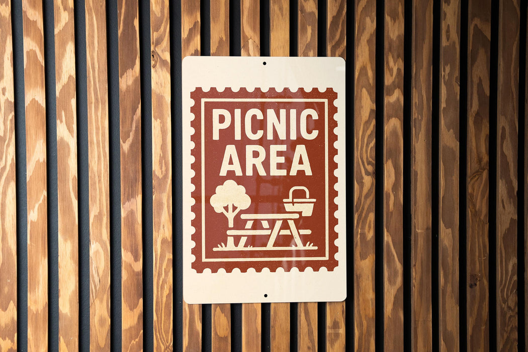 A sign indicating a picnic area is mounted on a wooden wall.