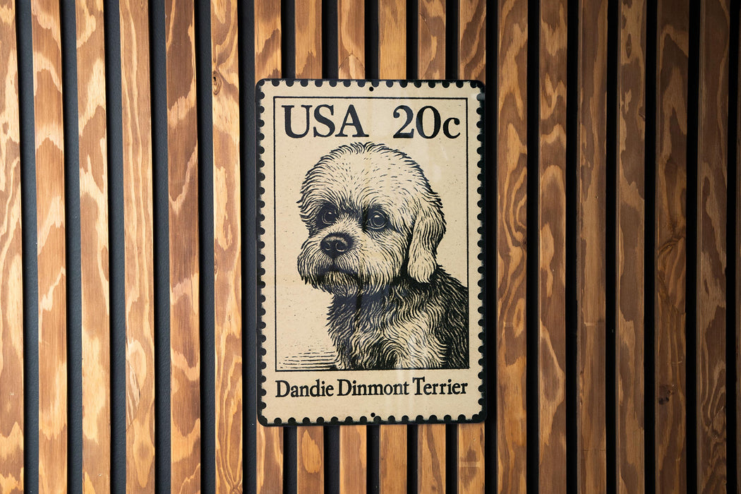 A black and white postage stamp featuring a Dandie Dimmont Terrier dog.