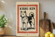 A framed illustration of a Shiba Inu dog, with the text "KISHU KEN" above it, is displayed on a shelf next to a wooden cutting board and some kitchen utensils.