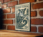 A metal sign featuring a sugar glider illustration is mounted on a brick wall.