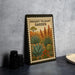 a metal sign with a desert garden theme, placed on a table next to some black camera lenses.