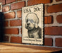 A metal sign featuring a Dandie Dinmont Terrier dog on a brick wall.
