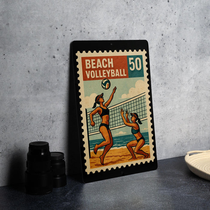 A framed vintage stamp depicting a beach volleyball game, with two players in action.