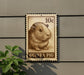 A 10c postage stamp featuring a guinea pig illustration is displayed on a wall.