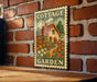 A vintage-style metal sign with a cottage garden illustration is mounted on a brick wall.