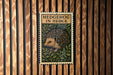 A wooden wall with a framed image of a hedgehog, which appears to be a decorative piece or a sign.