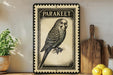 a vintage-style metal sign with a parakeet illustration, placed on a wooden surface next to a wooden cutting board and a potted plant.